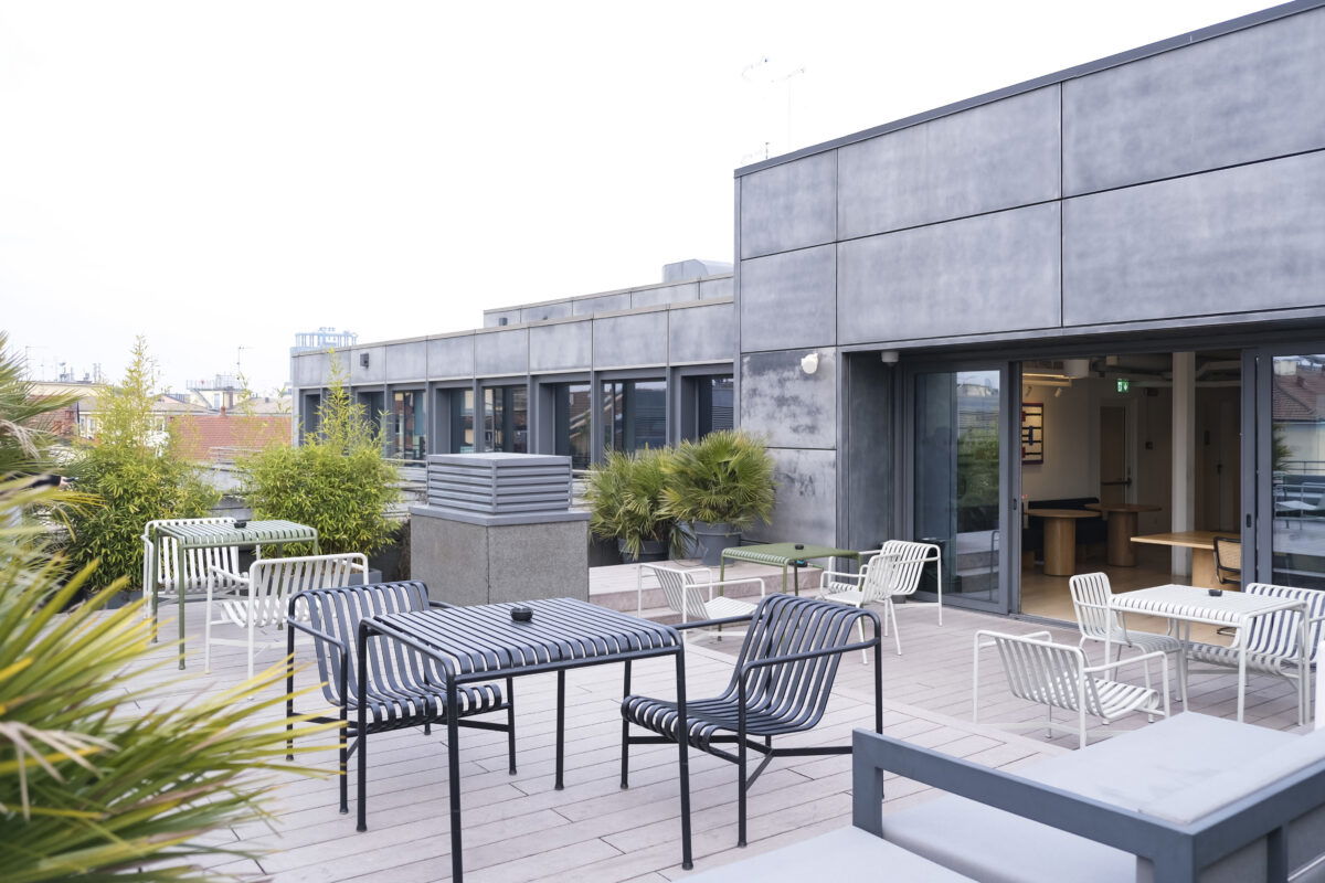 Terrazza con arredi da esterno e piante, affacciata sui tetti del centro di Milano.