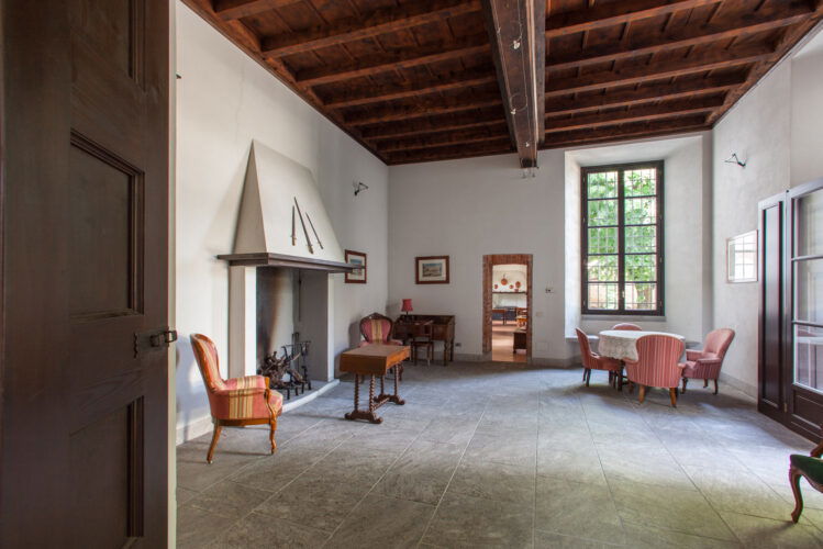Camino e arredi d’epoca in salone con soffitti alti