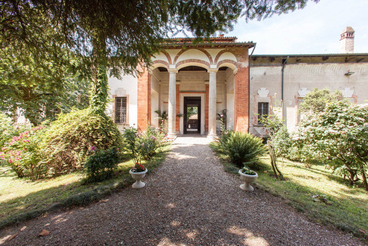 Facciata storica con vialetto d’ingresso immerso nel verde