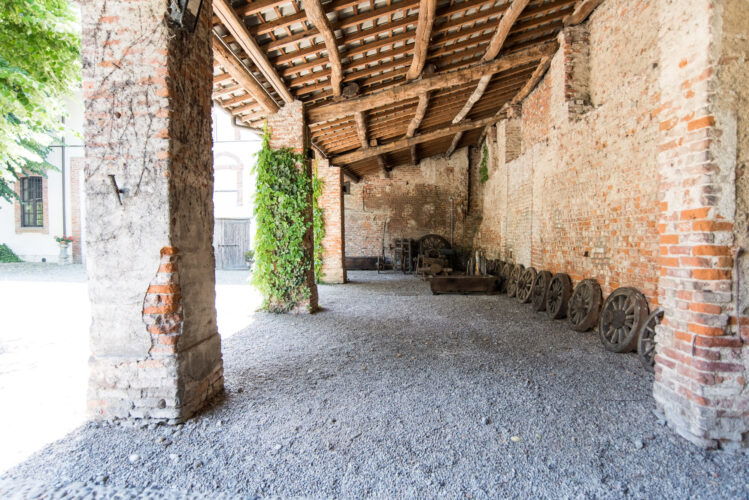 Spazio rustico con tetto a travi e carri antichi